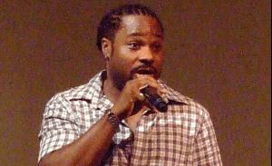 Malcolm Jamal Warner smiling during a red‑carpet appearance, embodying warmth and legacy