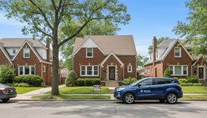 A brick rental home in Detroit featuring a Detroit property management sign and well-maintained landscaping.